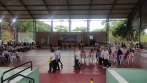 Na quadra coberta do CRPI, algumas pessoas idosas participam da oficina de cantiga de rodas.