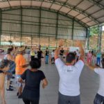 Pessoas idosas dançando na oficina de Cantigas de Roda.