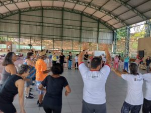 Pessoas idosas dançando na oficina de Cantigas de Roda.