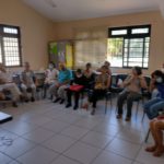 Pessoas idosas atentas à palestra sobre longevidade saudável.