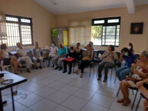 Pessoas idosas atentas à palestra sobre longevidade saudável.